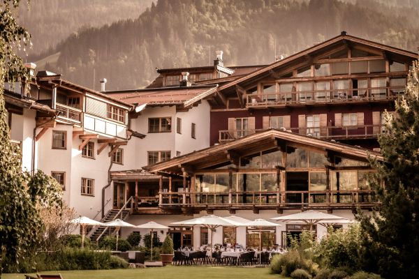 Charmantes Berghotel in idyllischer Alpenlandschaft bei Sonnenschein