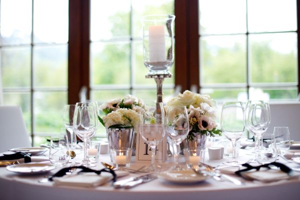 Elegant gedeckter Tisch mit Blumen und Kerzen in hellem Ambiente