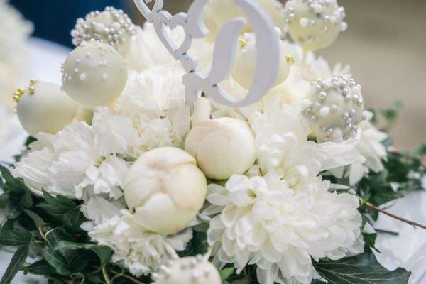 Elegantes Blumenarrangement mit weißen Blüten und Dekorationen