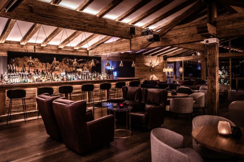 Gemütliche Bar im rustikalen Alpenschick mit stimmungsvoller Beleuchtung