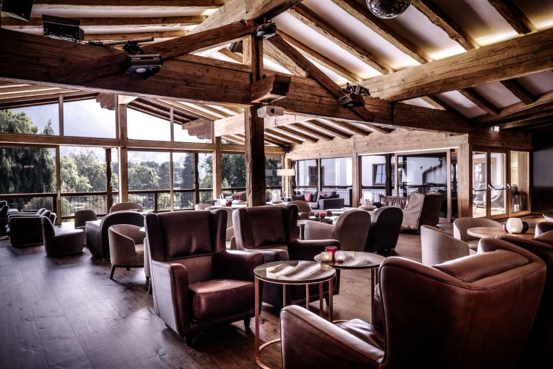Gemütliche Lounge mit Holzbalkendecke und Panoramafenstern