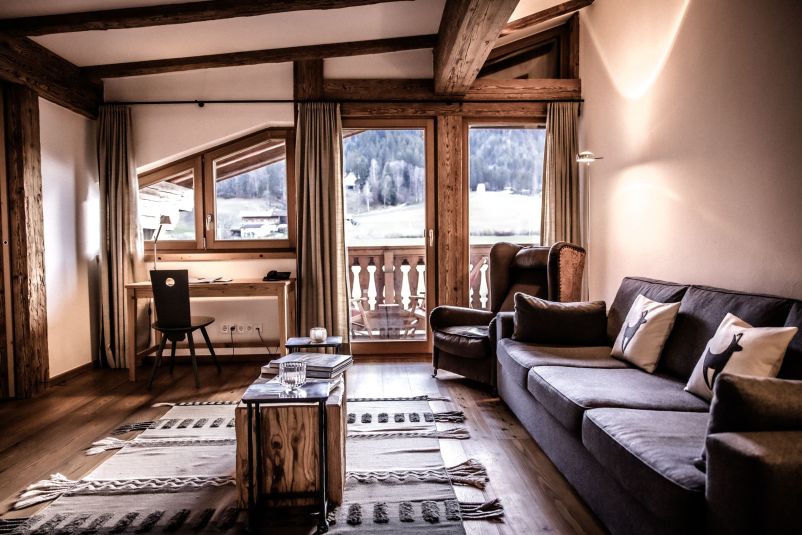 Gemütliches Chalet-Wohnzimmer mit Holzbalken und Bergblick