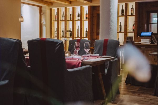 Gemütliches Restaurant mit stilvoller Weinauswahl im Hintergrund