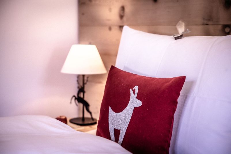 Gemütliches Schlafzimmer mit Hirschkissen und Leselampe