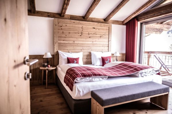 Gemütliches Schlafzimmer mit rustikalen Holzelementen und Balkon