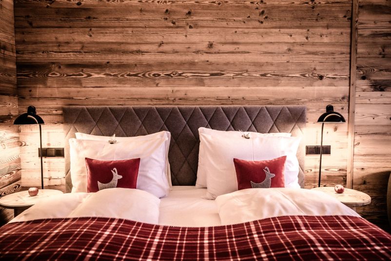 Gemütliches Schlafzimmer im alpinen Landhausstil mit Holzvertäfelung