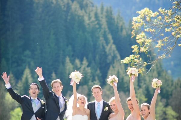 Fröhliche Hochzeitsgesellschaft feiert im Freien vor malerischem Wald