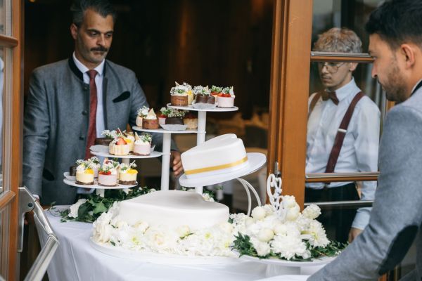 Elegante Hochzeitstorte mit Cupcakes wird für Feier vorbereitet