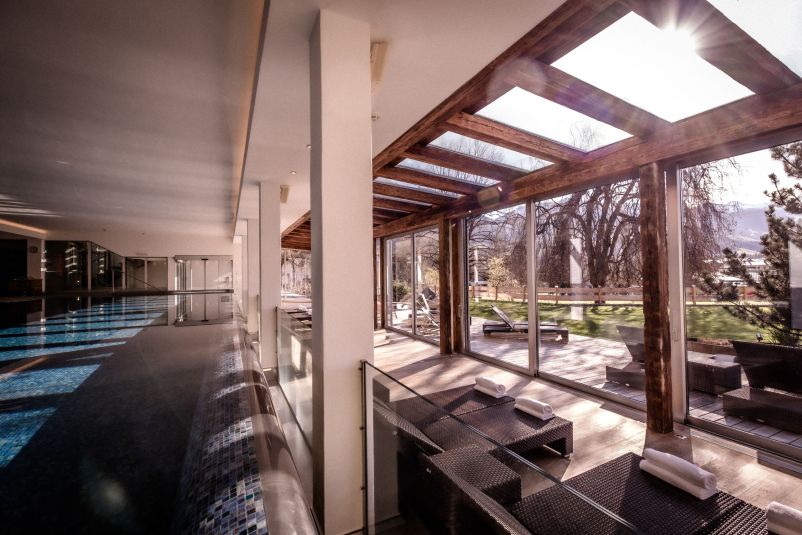 Moderne Entspannungs-Lounge mit Blick auf sonnige Außenanlage