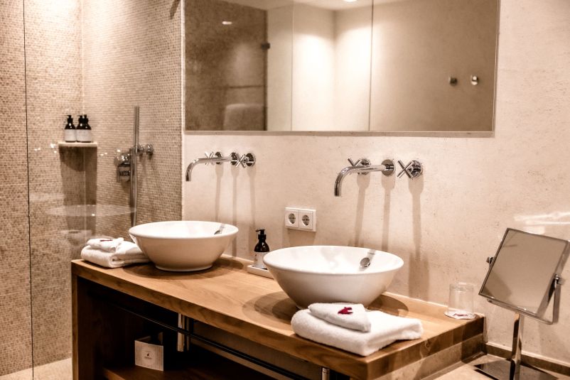 Modernes Badezimmer mit Doppelwaschbecken aus Holz und Glaswand