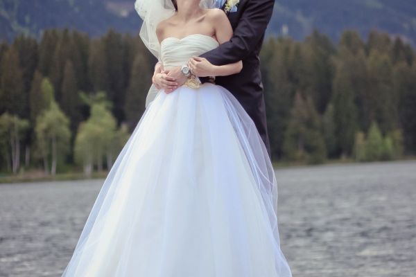 Romantisches Hochzeitsfoto am See mit Bergkulisse im Hintergrund