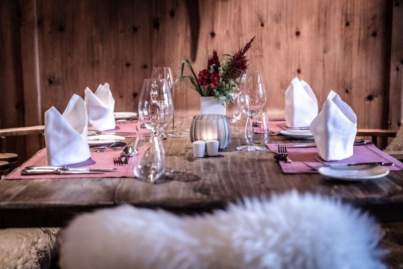 Elegantes, rustikales Esszimmer mit gedecktem Tisch, Kerzen und Blumenschmuck