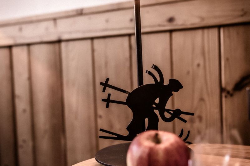 Rustikales Dekor: Skifahrer-Silhouette neben rotem Apfel
